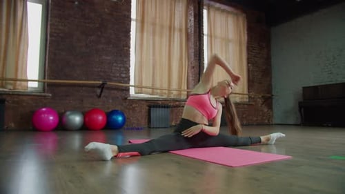 Young Woman Stretching in Splits Indoors