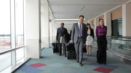 Business people walk through airport lobby