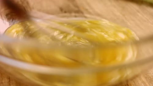 Macro View of Mixing Fresh Eggs Flour and Milk with Steel Hand Mixer in a Glass Bowl