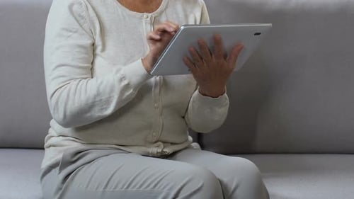 Senior Woman Using Tablet in Home Setting