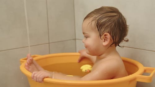 Baby in Yellow Tub Taking a Bath