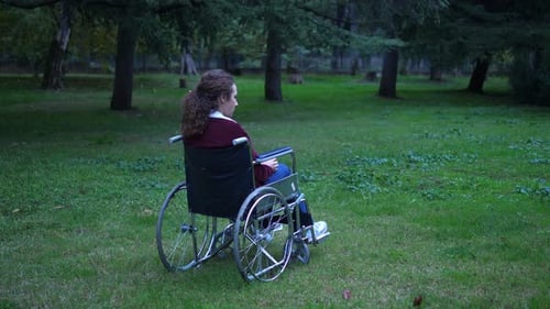 living with disabilities - young woman using wheelchair alone at the park