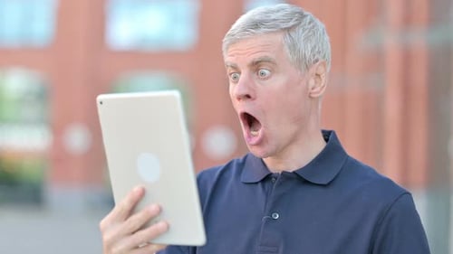 Man Shocked While Using Tablet Outdoors