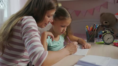 Mother And Daughter Doing Homework From School Together