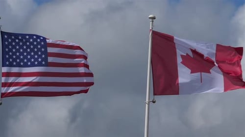 USA and Canada Flags Waving in the Wind