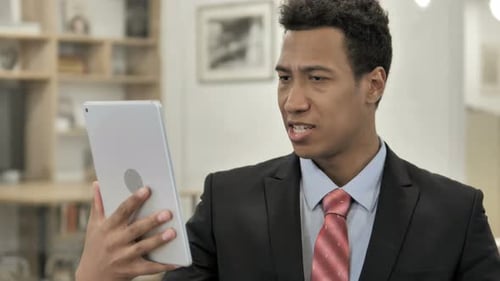 Man Video Conferencing on Tablet Indoors