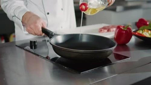 Chef Pouring Oil into Pan at Restaurant