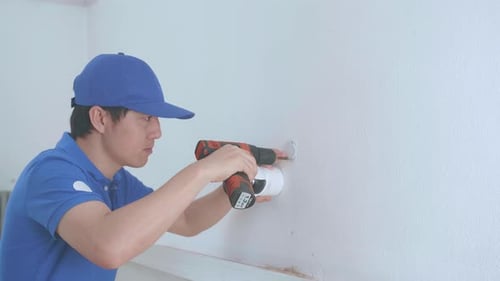 Young Adult Installs Security Camera With a Power Drill