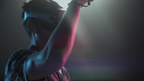 Young Adult Using Virtual Reality Headset in Dark Room
