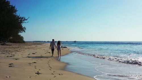 Two lovers sunbathing on tranquil seashore beach adventure by aqua blue ocean and white sandy backgr
