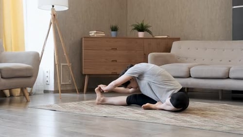 Woman Stretching on Rug in Brightly Lit Room
