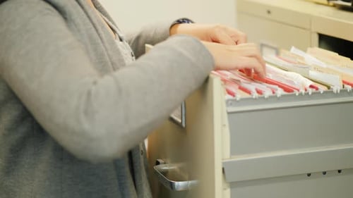Close-up of Female Hands Take a Folder with Documents From a Drawer in Retro Style