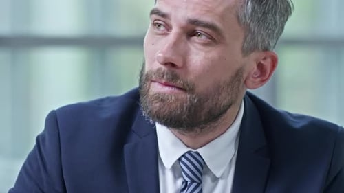 Man in Suit Writing in Notebook with Pen