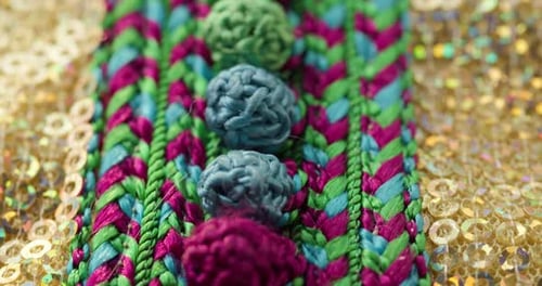 Motif de couleur tricoté sur tissu doré brillant avec gros plan à paillettes