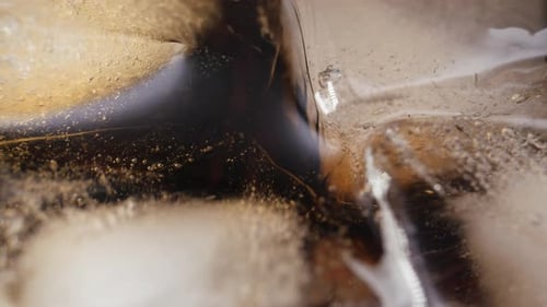Extreme Close Up of Ice Cubes in Dark Drink