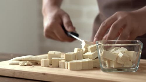 Hands Dicing Tofu on Cutting Board