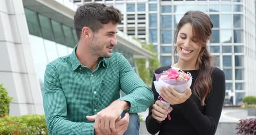 Loving Couple Exchanging Flowers in a City