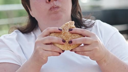 Adult Woman Enjoying Burger Close Up Outside