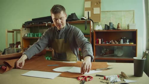 Leather Craftsman Measures Material at Workbench