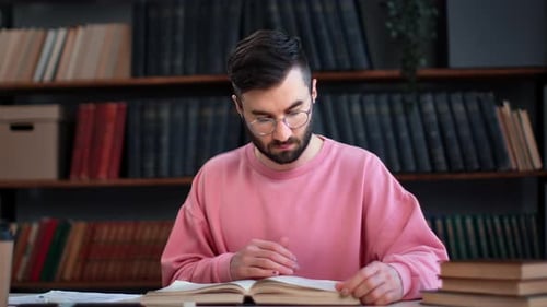 Selbstbewusster männlicher Student, der ein Vintage-Papierbuch liest, Bereiten Sie sich auf