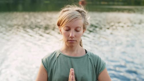 Woman Meditating by Lake in Nature Close Up