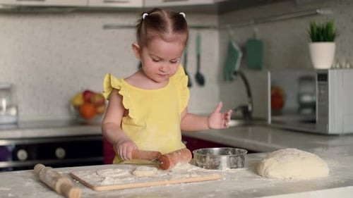 Happy Child 2 Years Old Prepares Pastries From Dough and Flour in the Kitchen at the Table