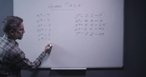 Man Explains Math Equations at Whiteboard