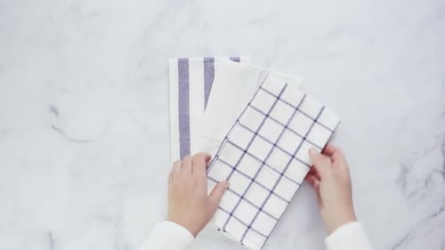 Hands Fold Clean Kitchen Towel on Marble