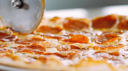 Pepperoni Pizza Being Cut into Slices