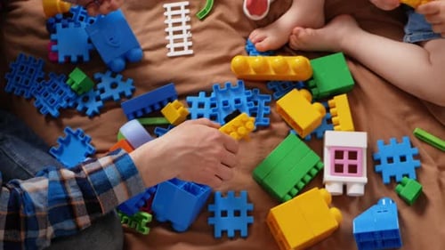 Vater und Tochter spielen mit Baukasten auf dem Bett im Schlafzimmer drinnen zu Hause