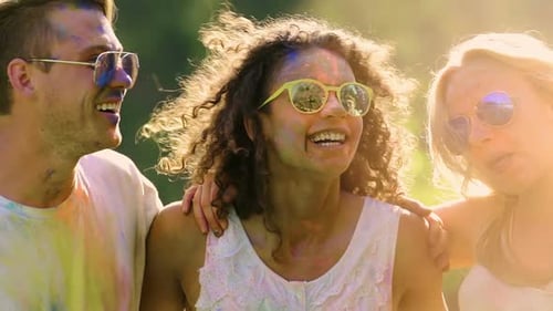 Happy Friends Faces in Powder Paint, People Dancing and Smiling at Holi Fest