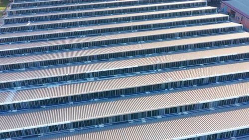 Saw-tooth pattern metal roof of a big factory in a production plant - abstract. Ridges on rooftop.