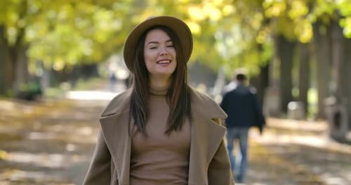 Beautiful Caucasian Girl in Elegant Brown Hat and Coat Posing on the Background of Autumn Park
