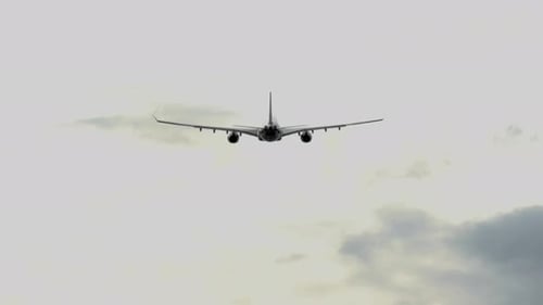Commercial Airplane Flying in Cloudy Sky
