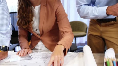 Team Reviewing Architectural Plans in Modern Office