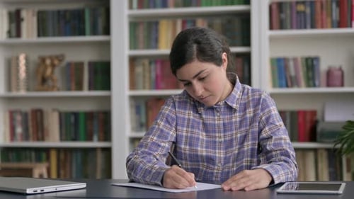 Indian Woman Writing on Paper in Office