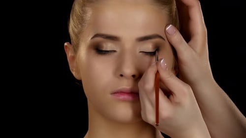 Maquillage professionnel, vue latérale de l'application du fard à paupières avec pinceau