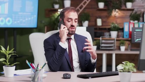 Man in Suit Talking on Cellphone in Office