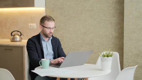 Man Working on Laptop at Home Table