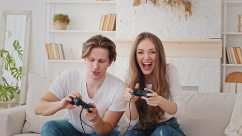 Excited Couple Playing Video Games Together on Couch