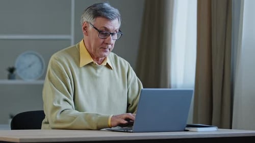 Senior Man Using Laptop at Home