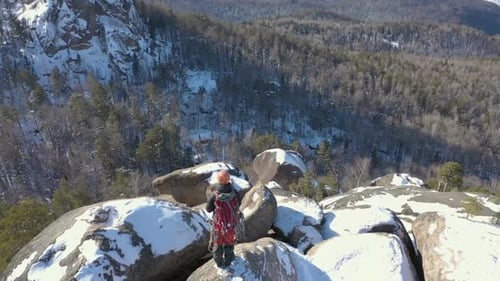 Aerial View of a Lone Male Climber on a Snowy Mountain Top.