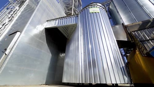 Metal granary at sunlight, Modern plant for processing agricultural harvest