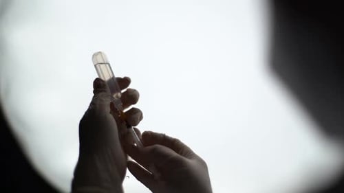 Gloved Hands Preparing Syringe With Medicine From Vial