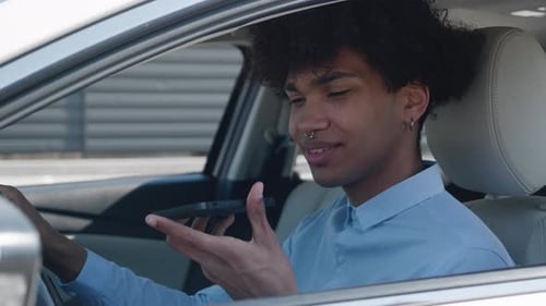 Young Adult Using Smartphone Voice Command in Car