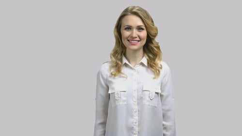 Smiling Woman Gives Thumbs Up on Gray Background