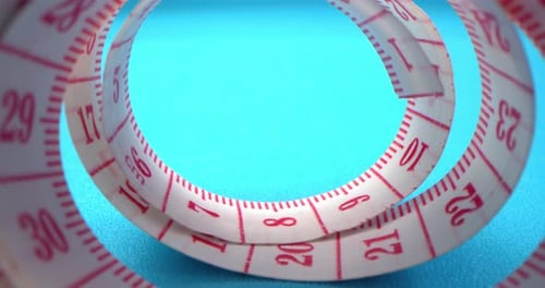 Super Macro Shot of a Measuring Tape Into a Roll of Sewing and Colored Thread on the Background Blue