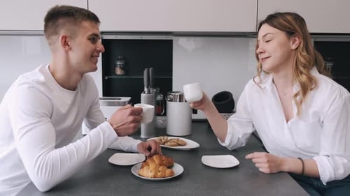 Young Couple Enjoying Breakfast in Modern Kitchen