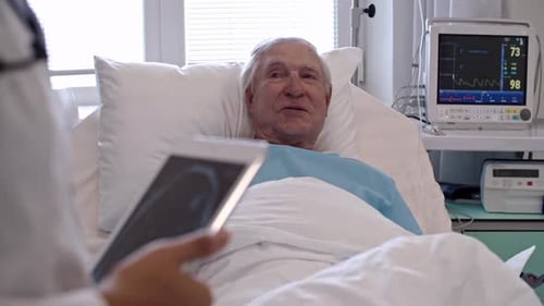 Senior Patient in Hospital Bed with Healthcare Provider