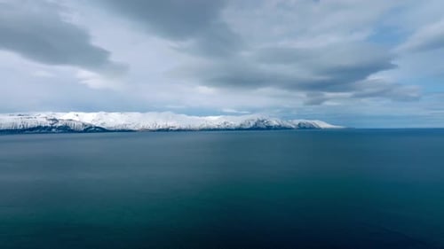 Aerial View of Serene Ocean with Snowy Mountains